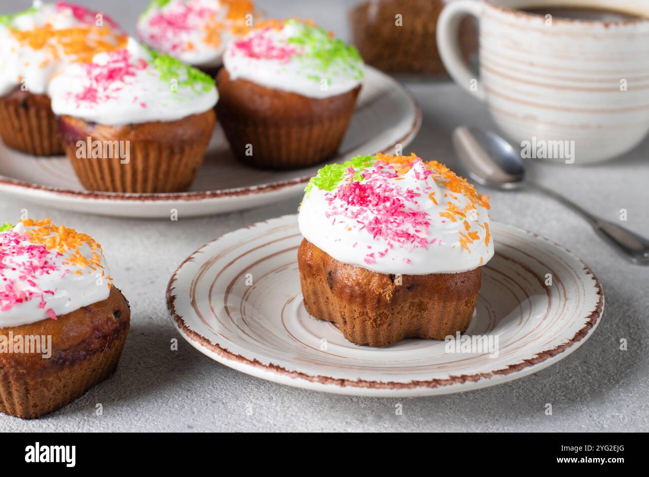 Cupcakes mit Proteincreme, bestreut mit bunten Kokosflocken Stockfoto