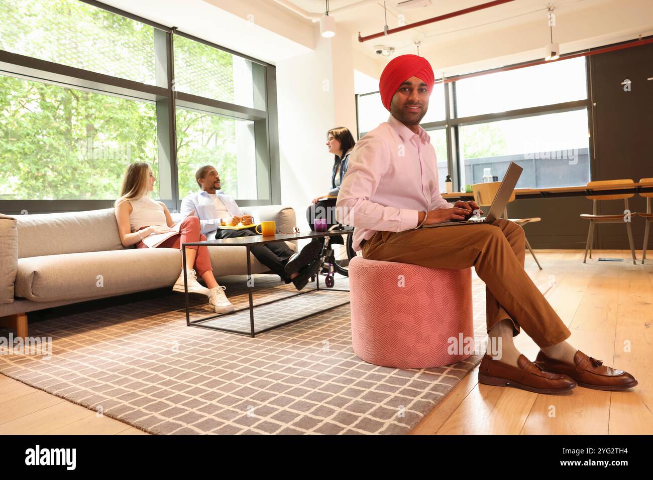 Geschäftsmann mit Sikh-Turban und Laptop im Büro Stockfoto