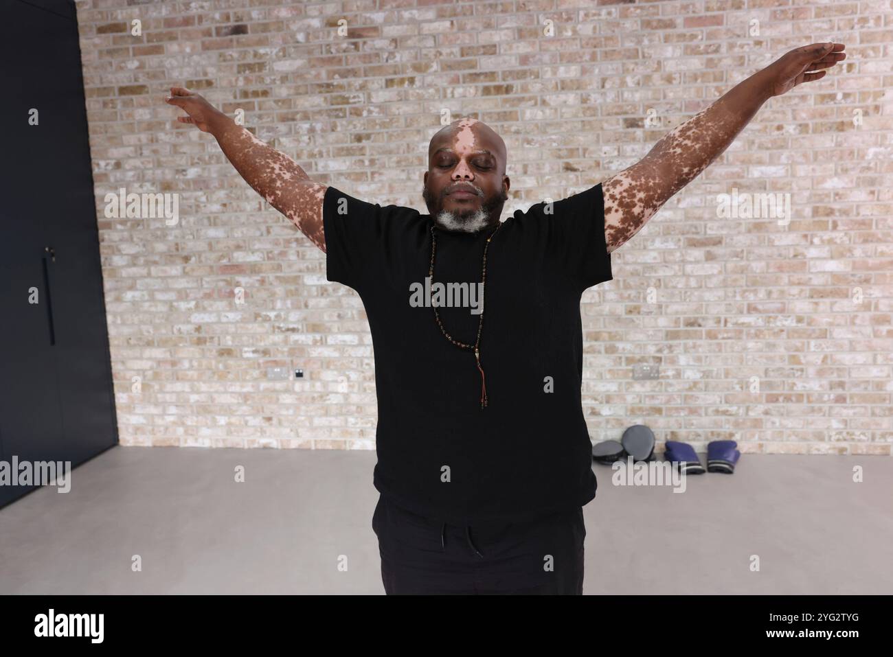 Der Mann, der die Arme während des Trainings im Fitnessstudio ausdehnt Stockfoto