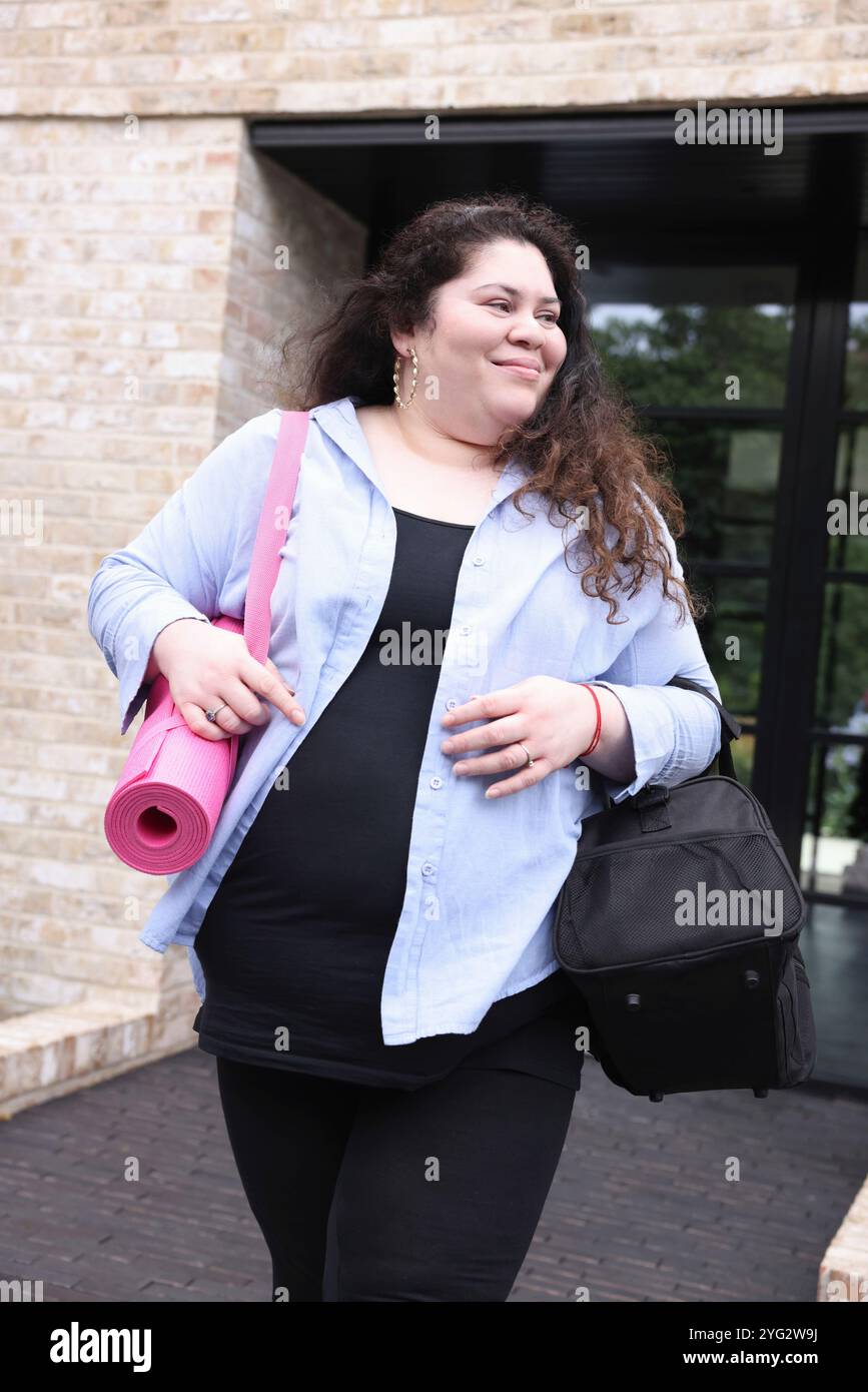 Glückliche Frau, die das Gebäude verlässt Stockfoto