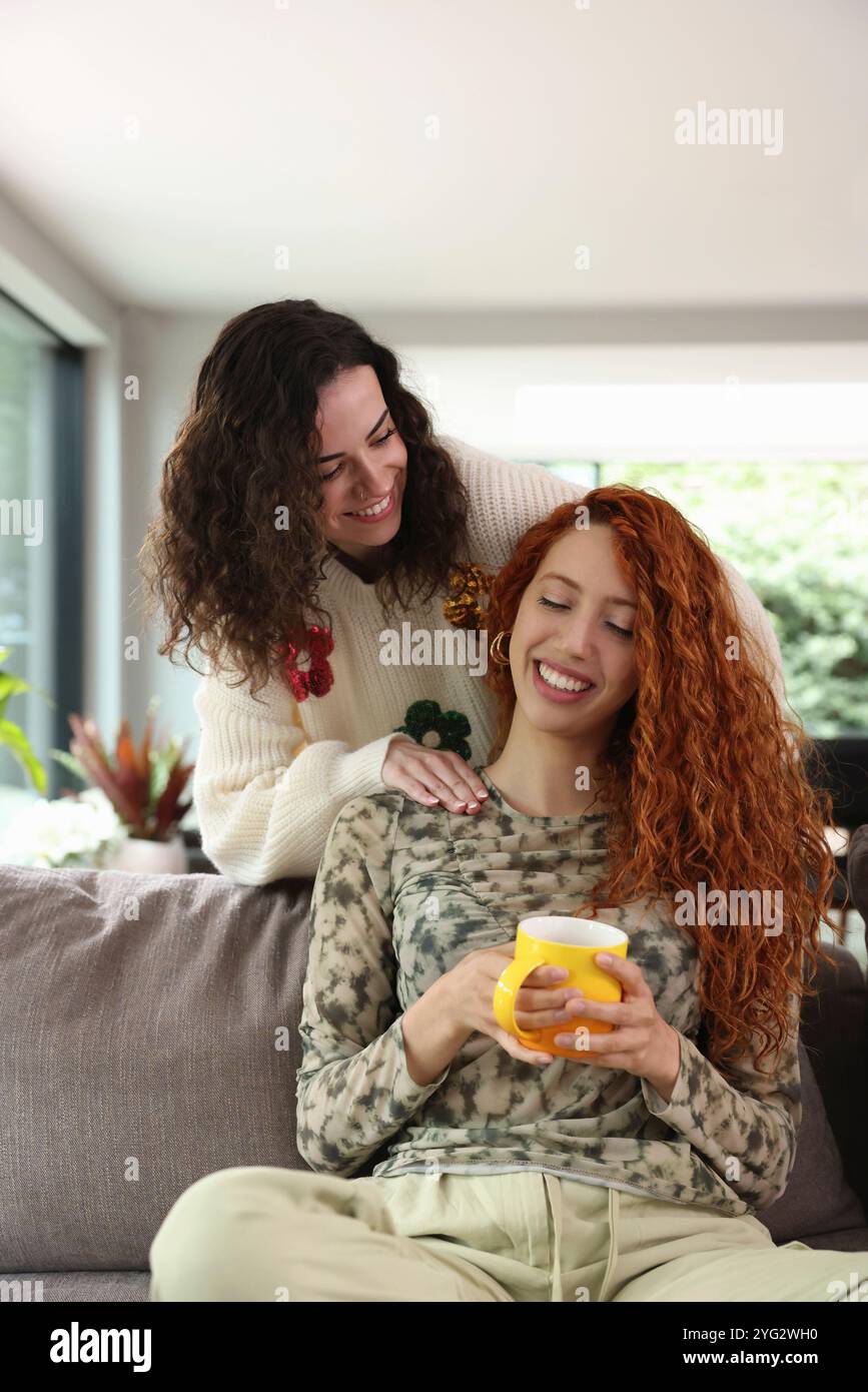 Zwei Frauen lachen im Wohnzimmer Stockfoto