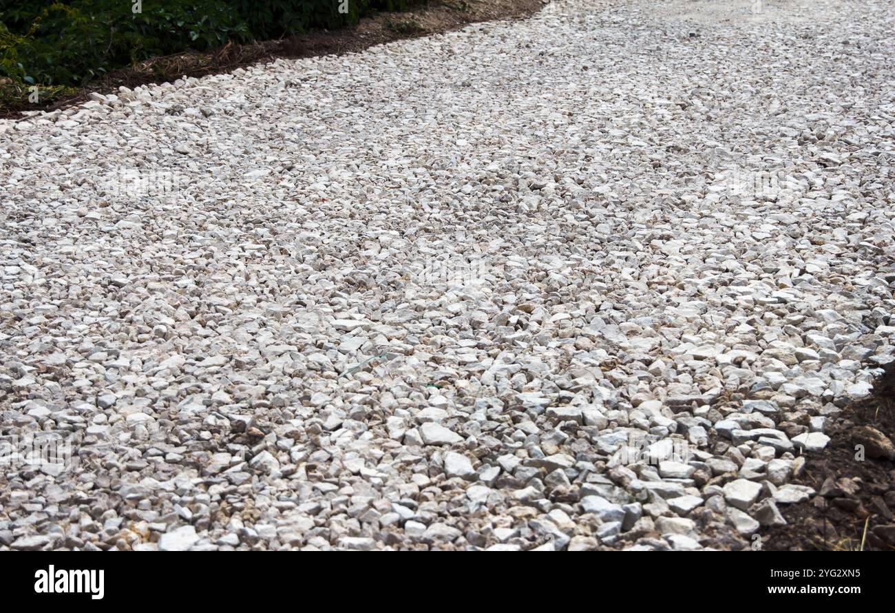 Es wird daran gearbeitet, eine neue Straße zu bauen und zu legen. Crushed Stone Close-up liegt auf dem Boden. Bruchstein. Stockfoto