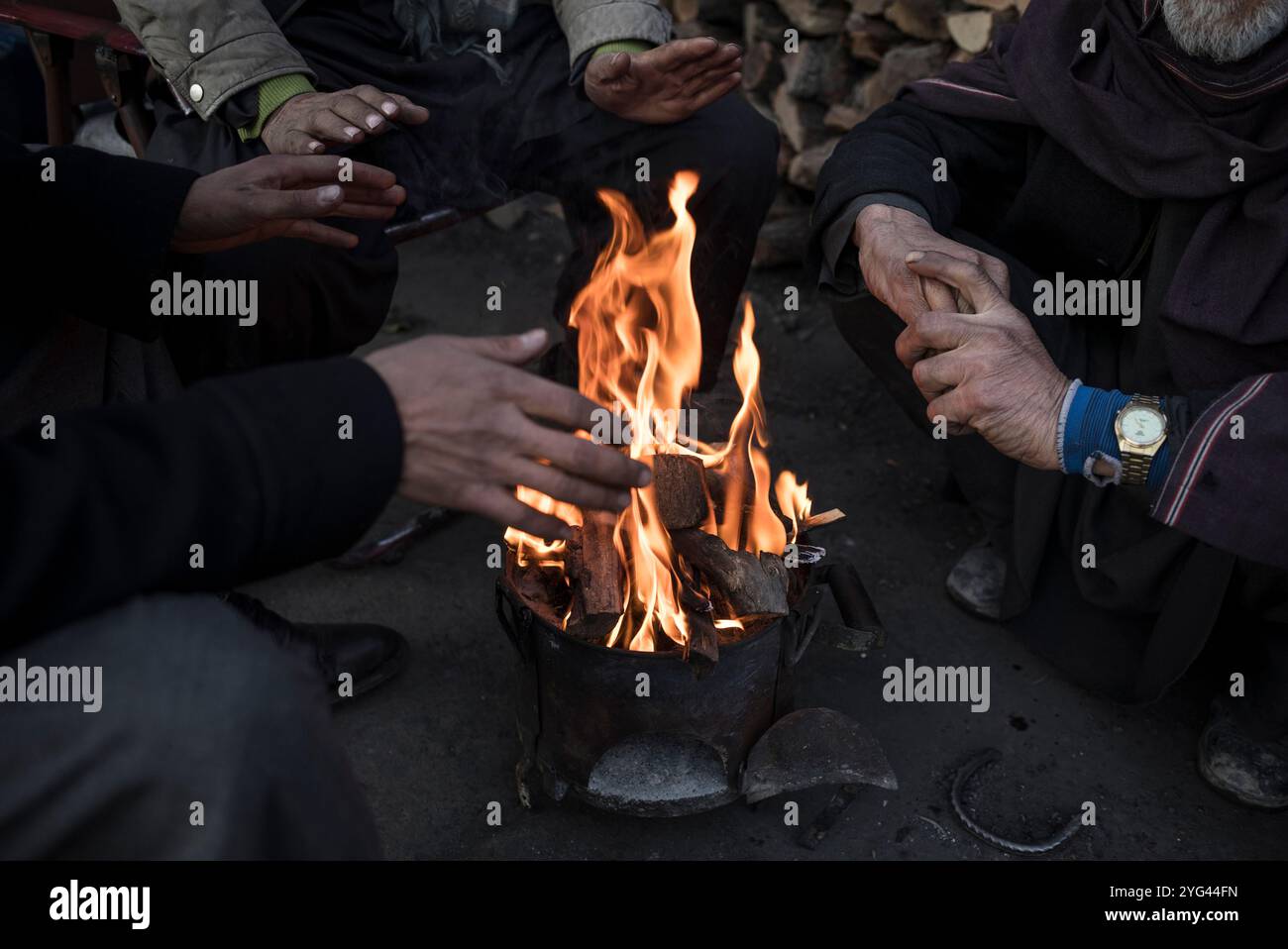 Kohlehändler halten sich warm, indem sie Holz auf einem Markt zünden, wie der Abend hereinbricht, Kabul, Afghanistan, 2. Februar 2020. Die Hauptstadt Kabul, eine Stadt von etwa sechs Millionen Stockfoto