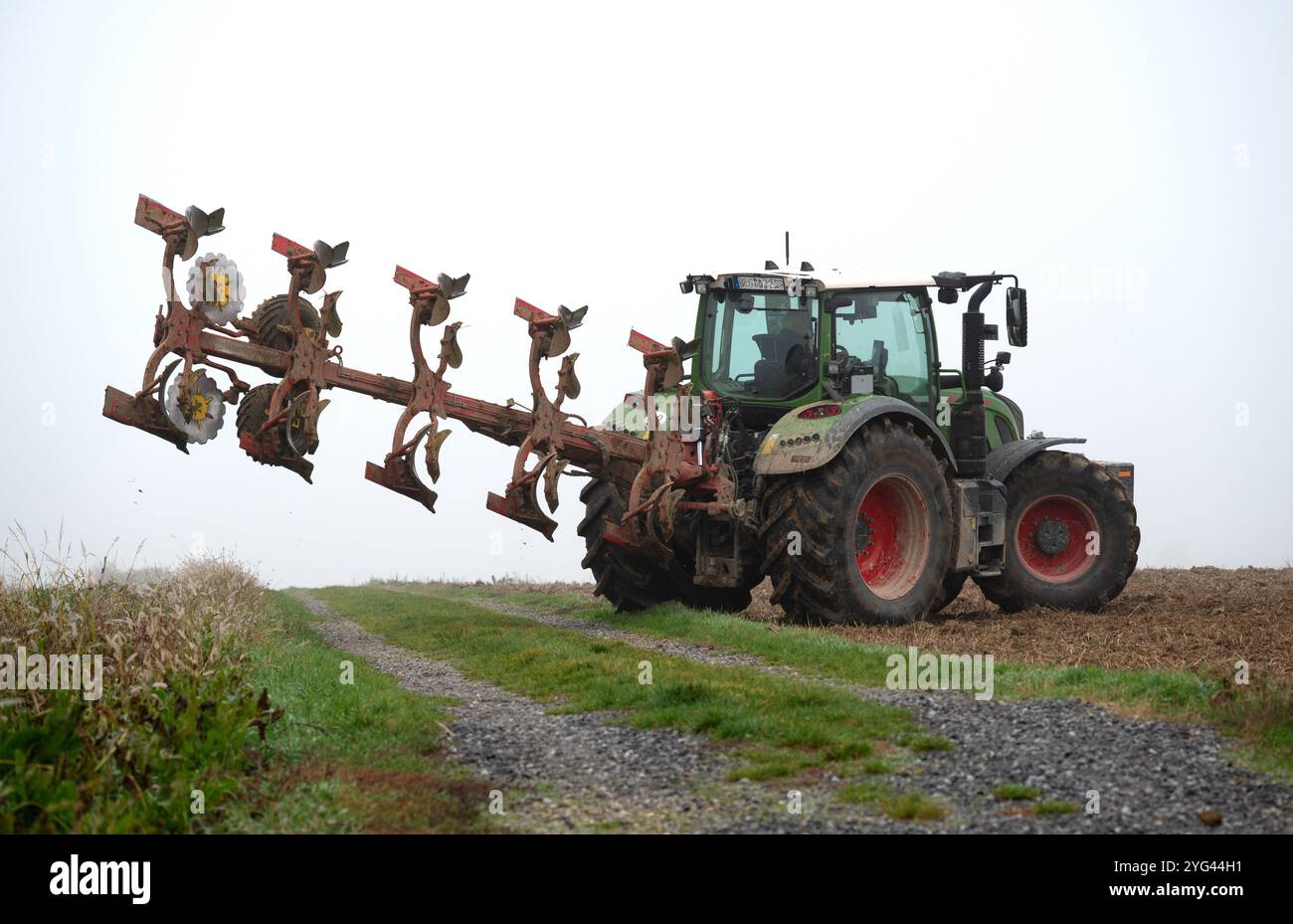Ein Landwirt pflügt im Herbst mit einem Traktor mit einem 5-Furchenpflug und 5-geteiltem Wendepflug Stockfoto