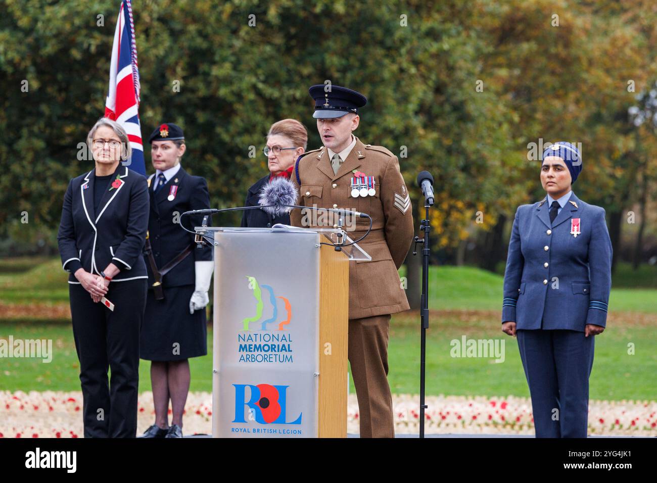 Eröffnung des Gedenkmohnfeldes am National Memorial Arboretum im November 2024. Mohnblumen wurden auf dem Feld platziert, um an die Verstorbenen in den Weltkriegen und Konflikten zu erinnern. Während der Gedenkfeier fanden zwei Mitglieder der Gruppe „Talent in the Ranks“ statt, Lee Wright (ein Gedicht vorlesen) und Michael Lauchlan (ein Lied vorführen). Stockfoto