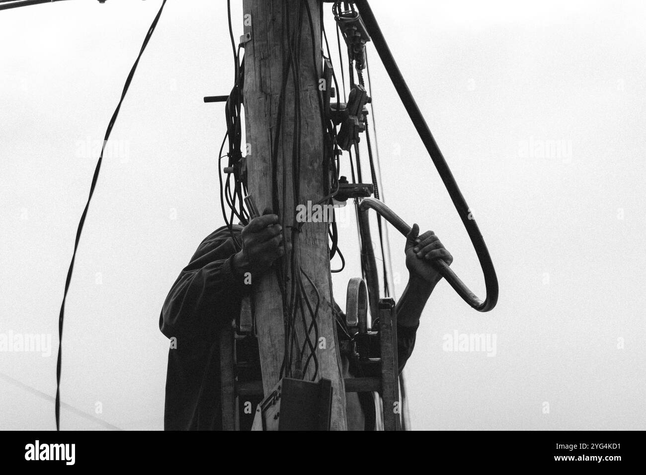 Überlasteter industrieller Elektromast mit mehreren Drähten für Kommunikation und Stromversorgung Stockfoto