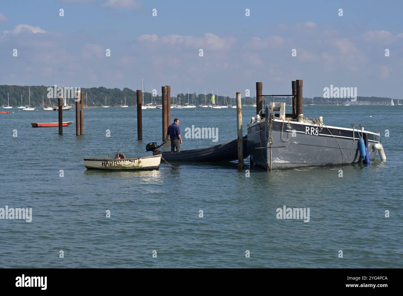 Junger Bootsmann, der altes Restaurierungsprojekt bewegt, klassisches Boot, Pinmühle, suffolk, england Stockfoto