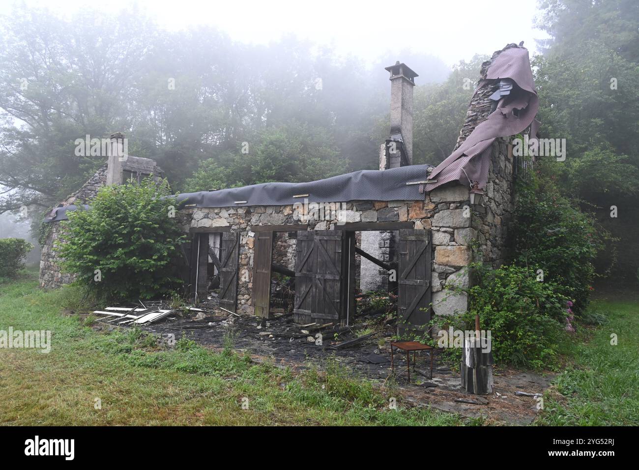 Ruine und verlassenes Haus nach der Zerstörung durch Feuer in Mysteriou Misty Landscape Stockfoto