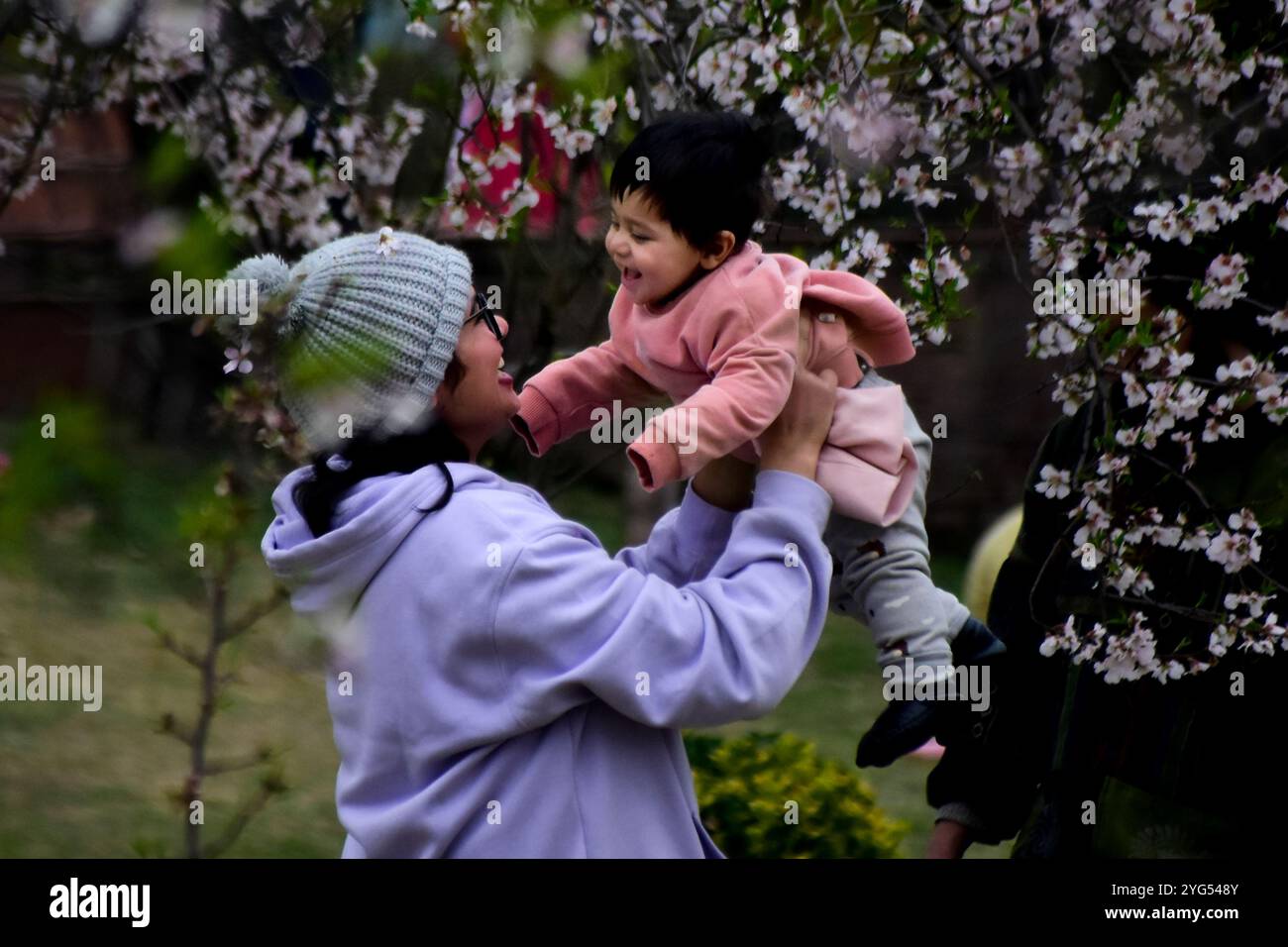 Srinagar, Kaschmir. 21. März 2021. Einheimische und Besucher genießen die Landschaft und den Badamwari-Garten und seine blühenden Mandelbäume in Srinagar, im indischen Kaschmir. Der Garten, der am 21. März für die Öffentlichkeit geöffnet wurde, befindet sich in den Ausläufern des historischen Hari Parbat oder „Koh-e-Maran“ Hügels mit der Festung Durrani und ist ein wichtiger Ort in Srinagar sowohl für Einheimische als auch für Touristen Stockfoto