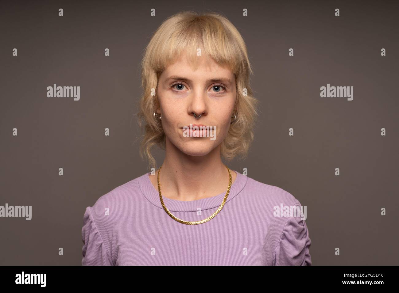 Modernes Porträt junger Menschen mit authentischem Ausdruck - zeitgenössischer Stil und persönliches Identitätskonzept - junge Frau mit Blick auf die Kamera Stockfoto