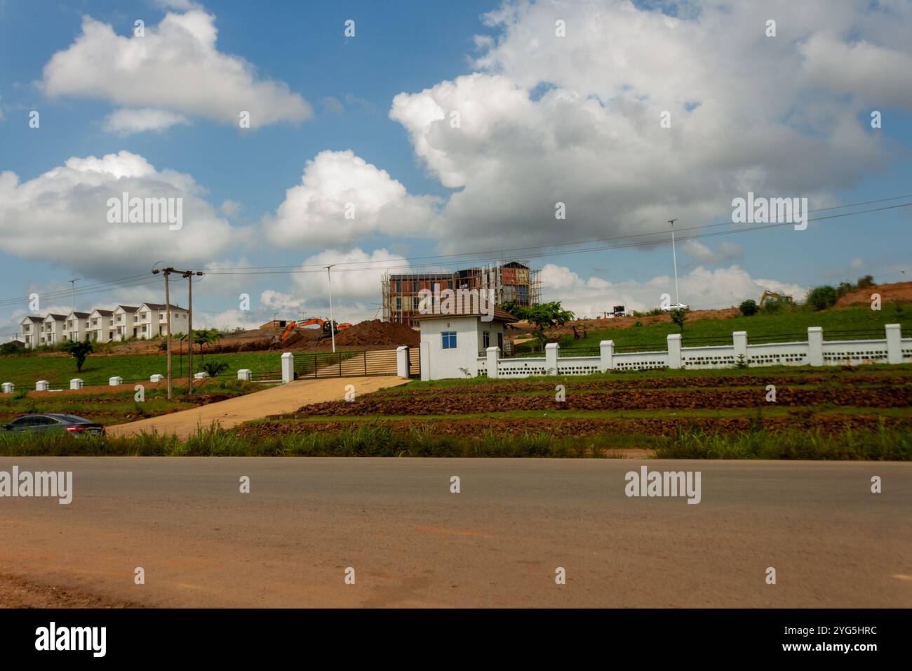Städtische Baustelle mit Bagger und Baugerüst unter bewölktem Himmel in Enugu, Nigeria Stockfoto