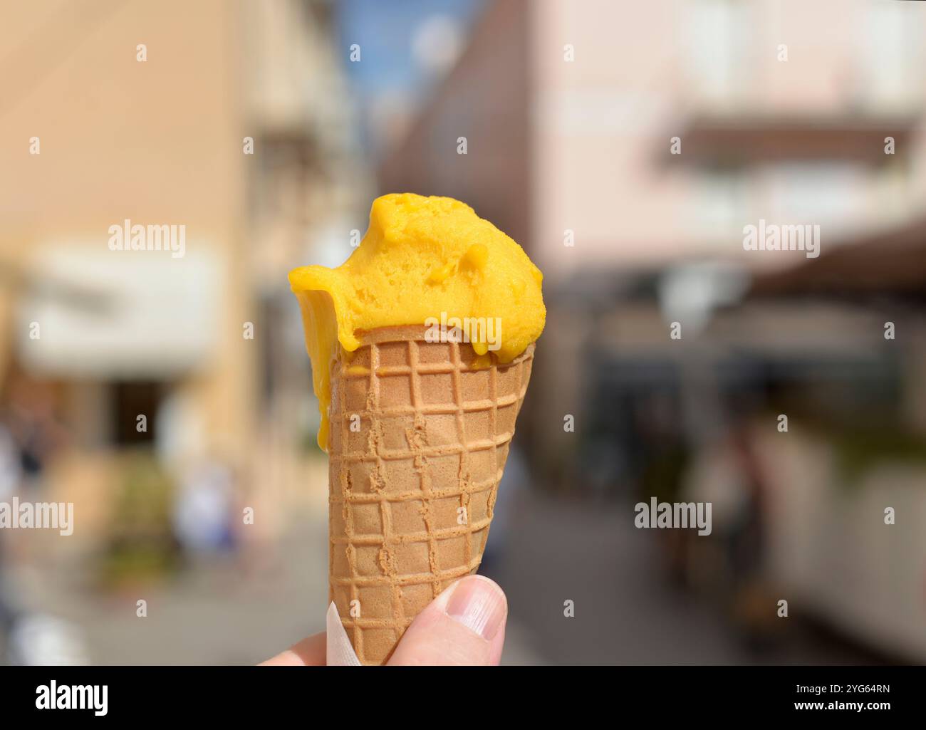Die Hand hält Mangobeis und läuft auf der Straße Stockfoto