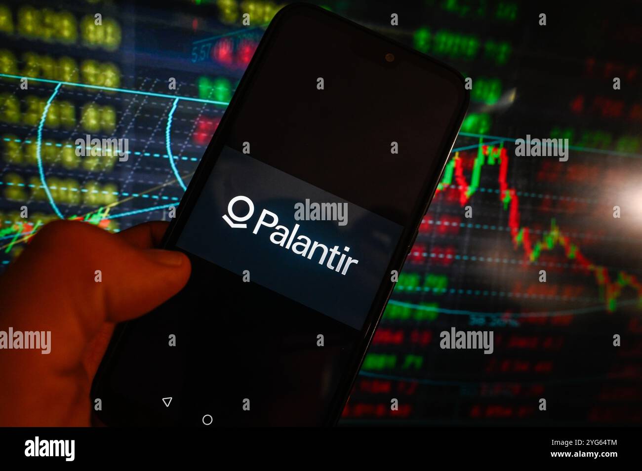 In dieser Fotoabbildung wird auf einem Smartphone ein Palantir-Logo mit Aktienmarktanteilen im Hintergrund angezeigt. Stockfoto