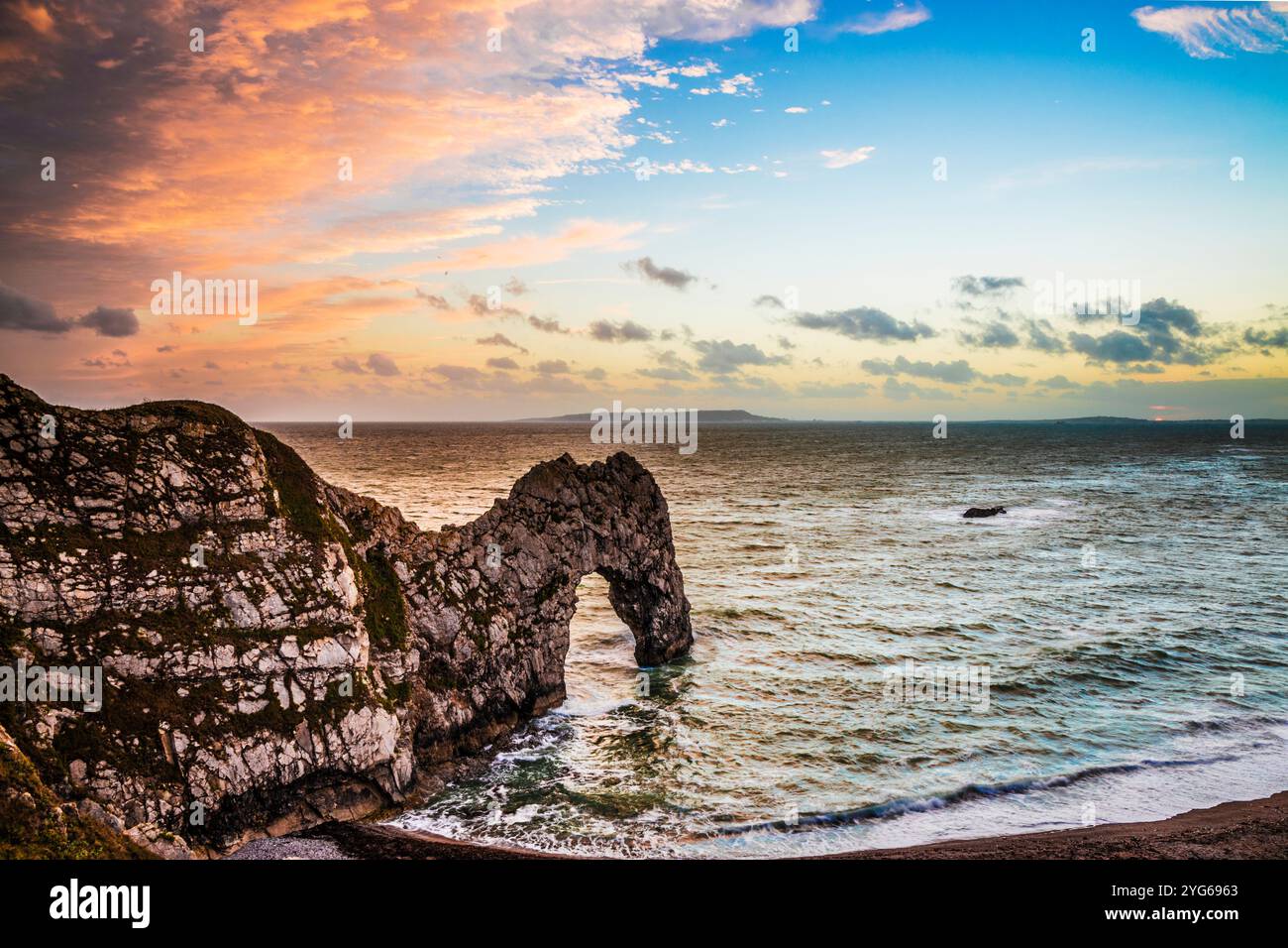 Sonnenuntergang am Durdle Door mit Blick auf Portland. Stockfoto