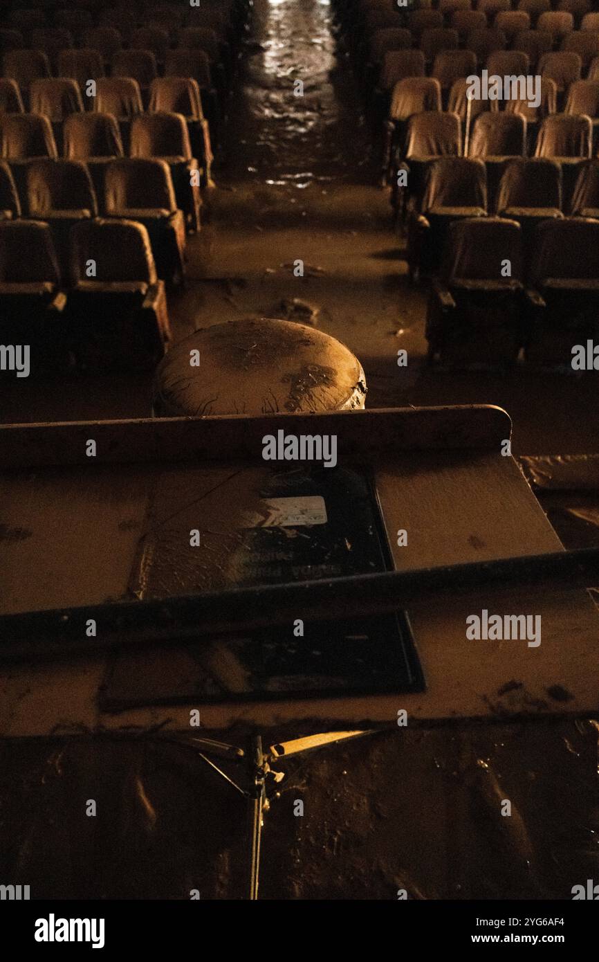 Paiporta, Valencia, Spanien - 4. November 2024. Das Auditorium in Florida wurde während der Überschwemmung in Paiporta zerstört, dem Boden Null der Naturkatastrophe. In diesem Theater spielte die „Primitiva Band“, ein Musikkollektiv, das in der Region berühmt ist. Luis, der Besitzer, zeigt an der Wand, auf welche Höhe das Hochwasser stieg und lässt einige der Instrumente unberührt. Im Regie-Platz gibt es noch eine Partitur für Hochsax, eines der Instrumente, die Vivian, der Regisseur, gespielt hat. Quelle: Roberto Arosio/Alamy Live News Stockfoto