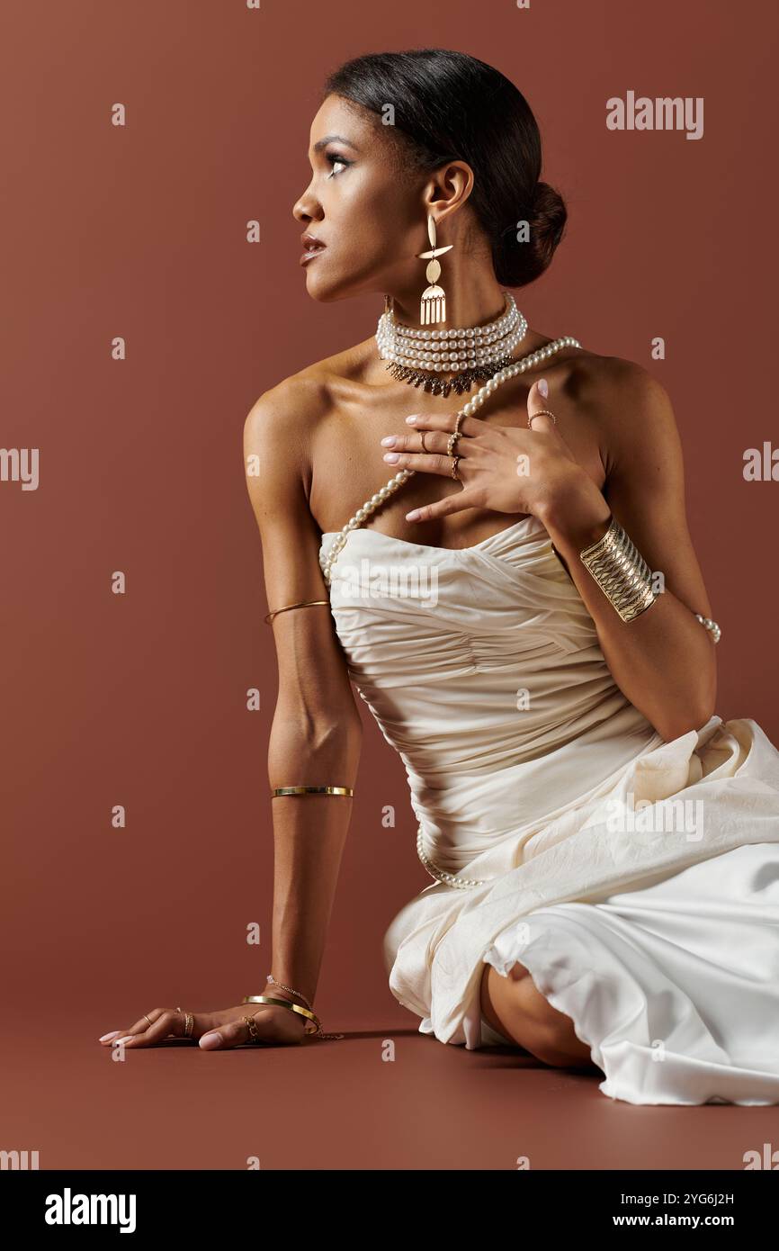 Eine atemberaubende afroamerikanische Frau schmückt sich mit Perlen und zeigt Eleganz und Schönheit vor einem warmen Hintergrund. Stockfoto