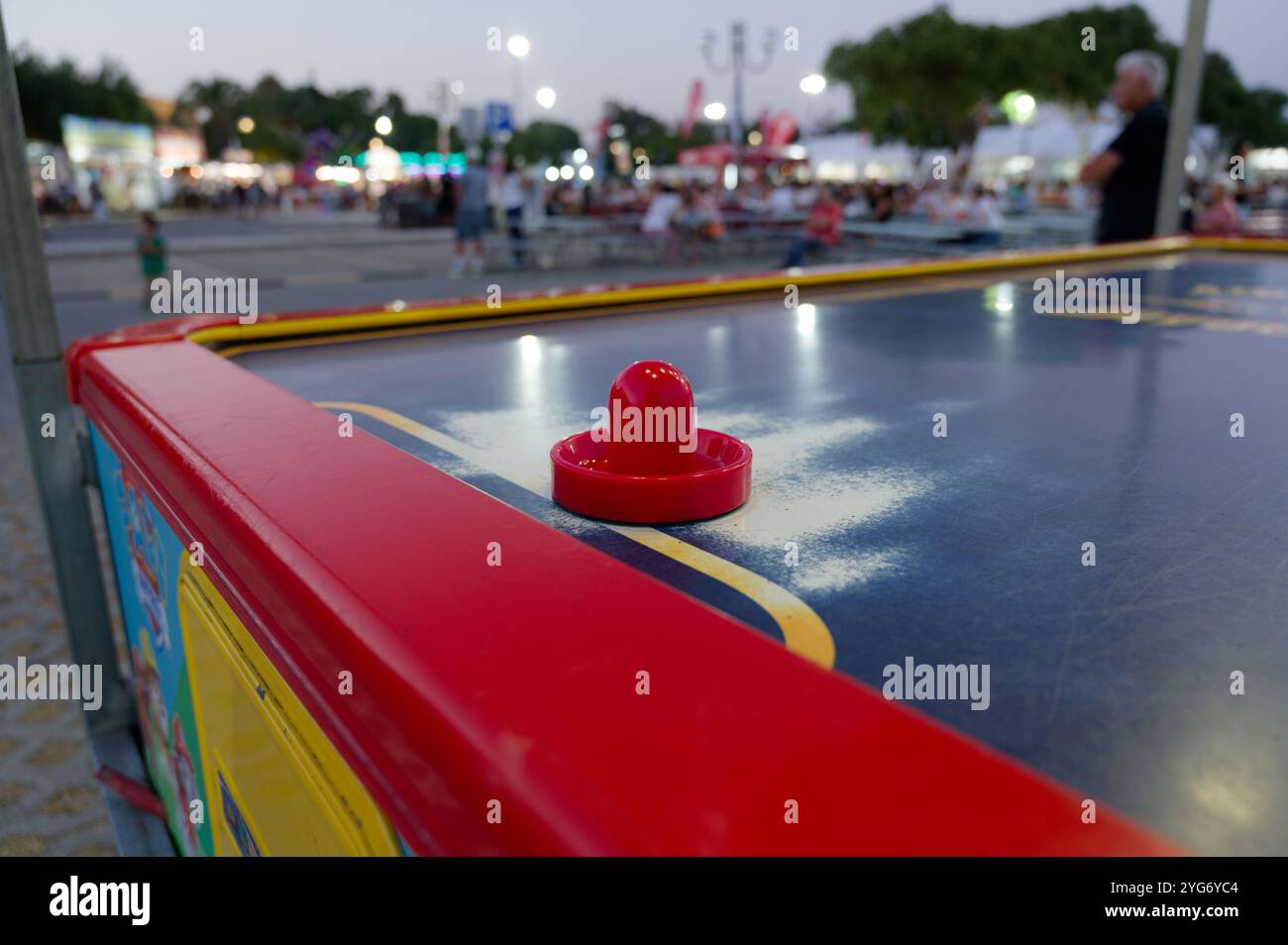 Nahaufnahme eines Air-Hockey-Paddels auf einem farbenfrohen Spieltisch auf einer Abendmesse Stockfoto