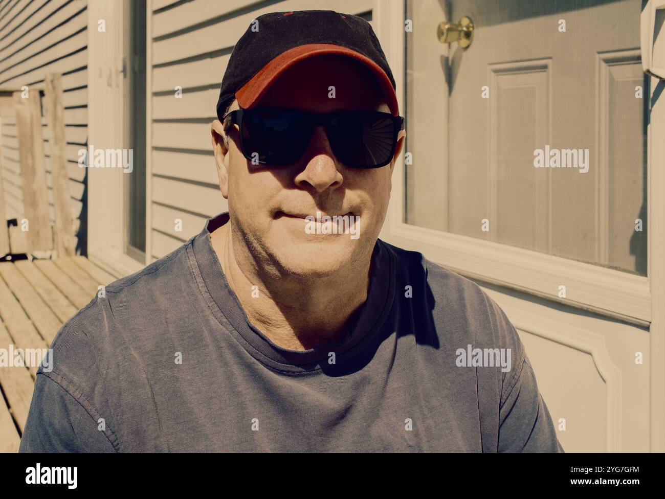 Lässiges Guy Porträt draußen zu Hause an einem sonnigen Tag. Vintage-Look. Stockfoto