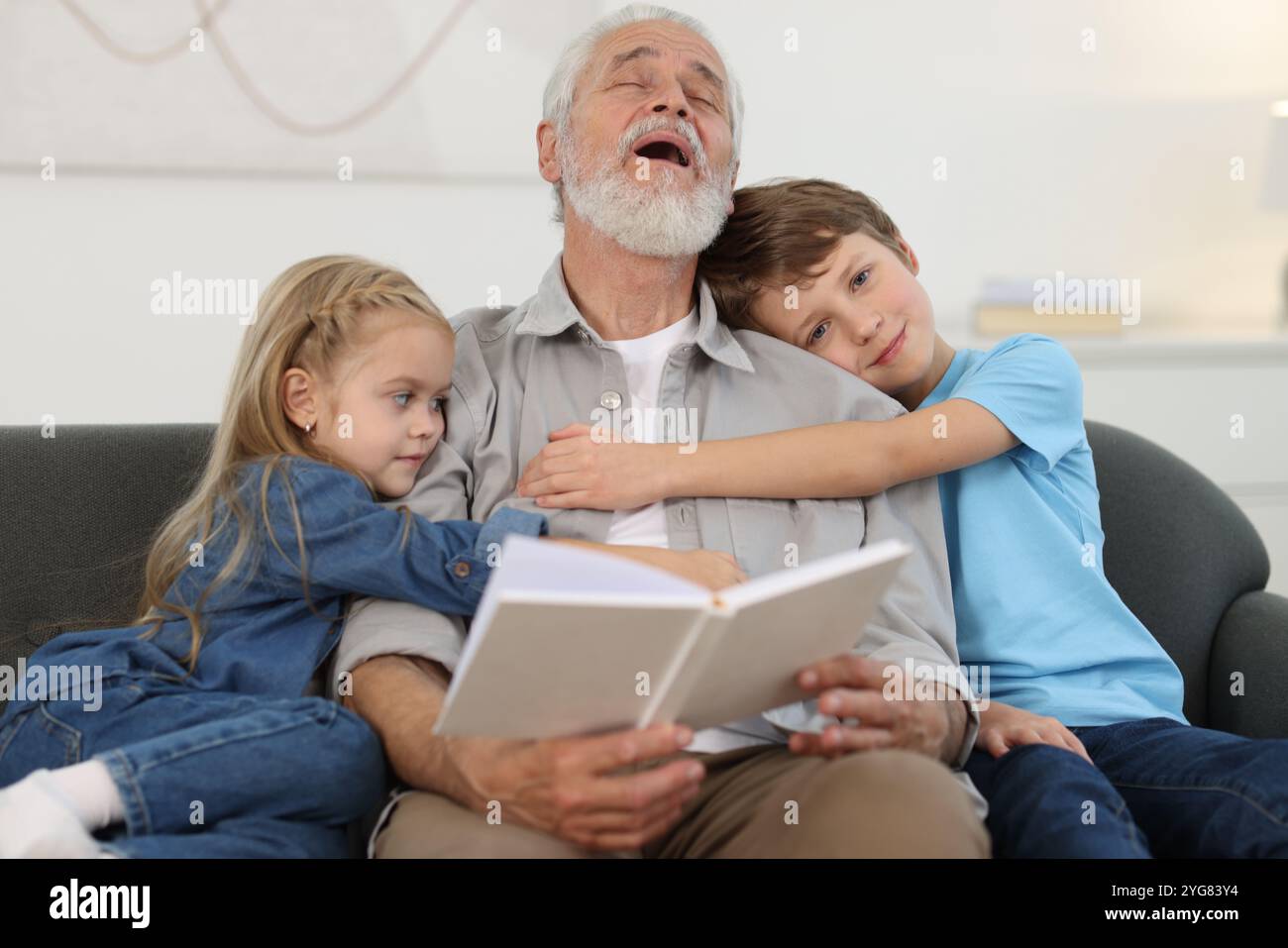 Opa und seine Enkel auf dem Sofa zu Hause Stockfoto