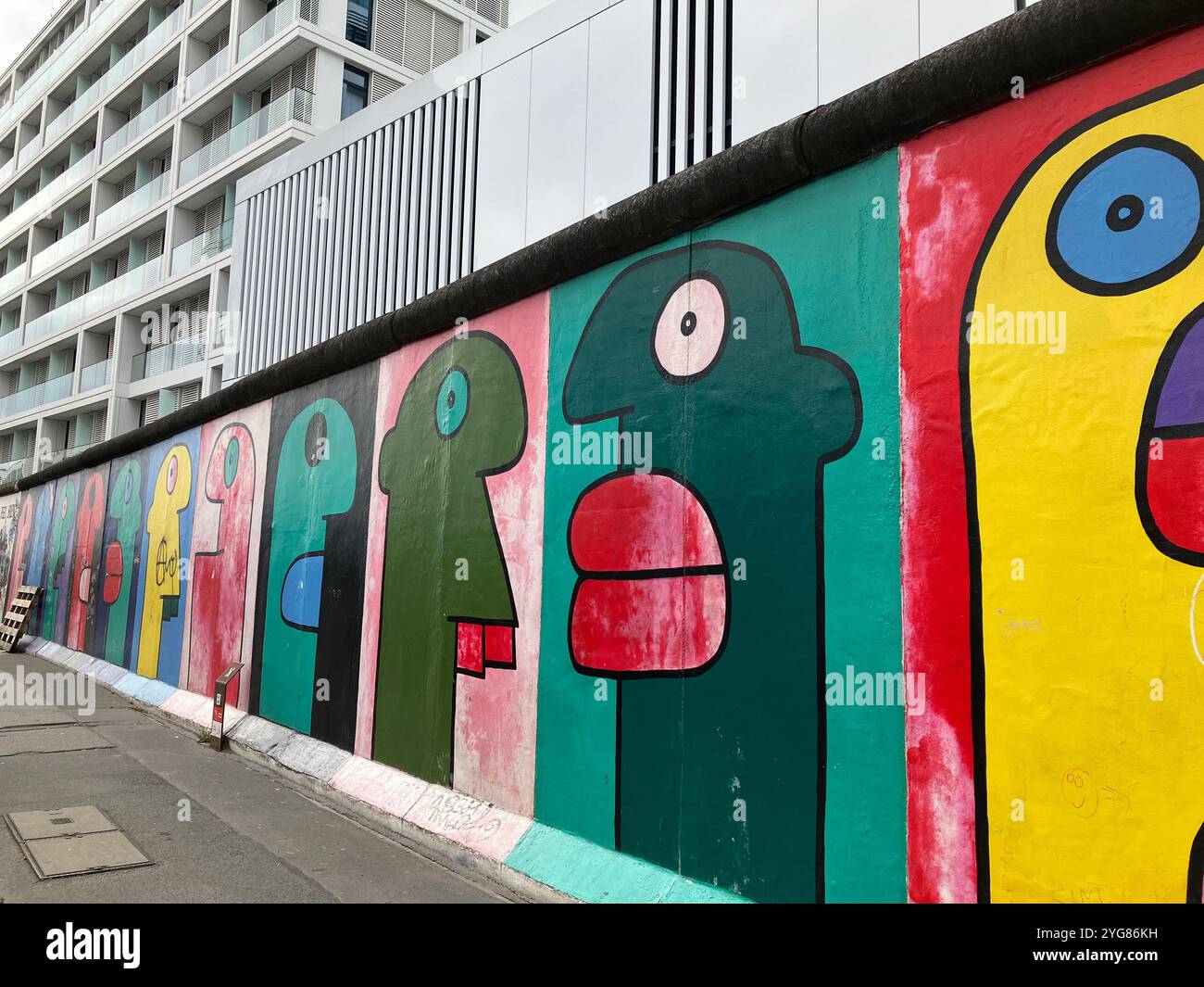 Köpfe von Thierry Noir auf der East Side Gallery, dem längsten erhaltenen Abschnitt der Berliner Mauer. Berlin, Deutschland. Oktober 2023 Stockfoto