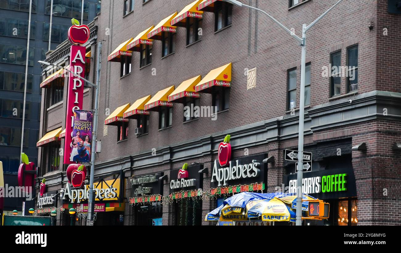 NEW YORK, NY USA - 10. JANUAR 2024: Ein Applebee's Restaurant mit gelben Markisen und einem großen roten Apfellogo ist mitten in einer Stadtstraße zu sehen Stockfoto