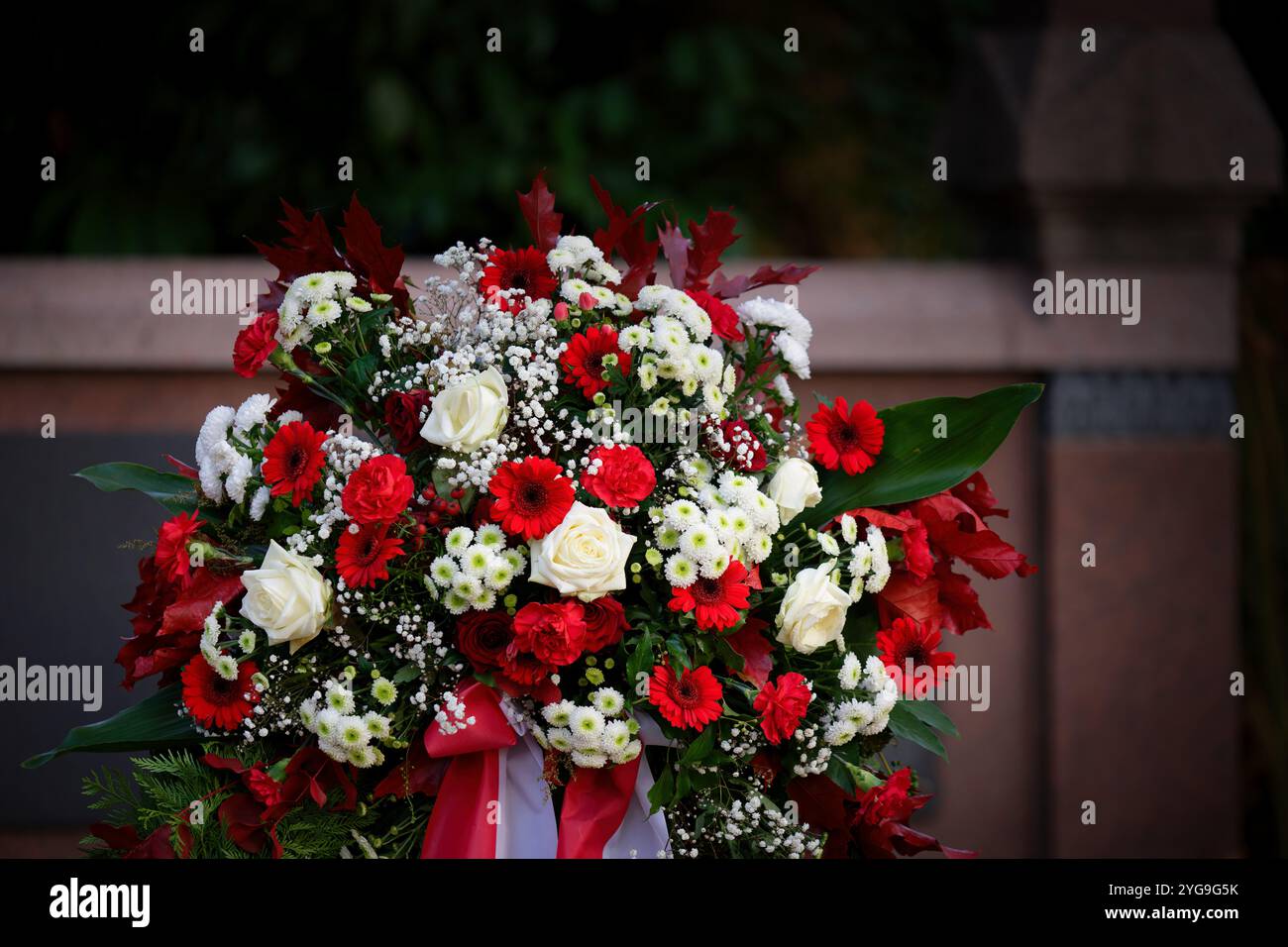 Eine repräsentative rot-weiße Beerdigung auf einem Stand an einem Grabstein an allen Seelen Tag Stockfoto