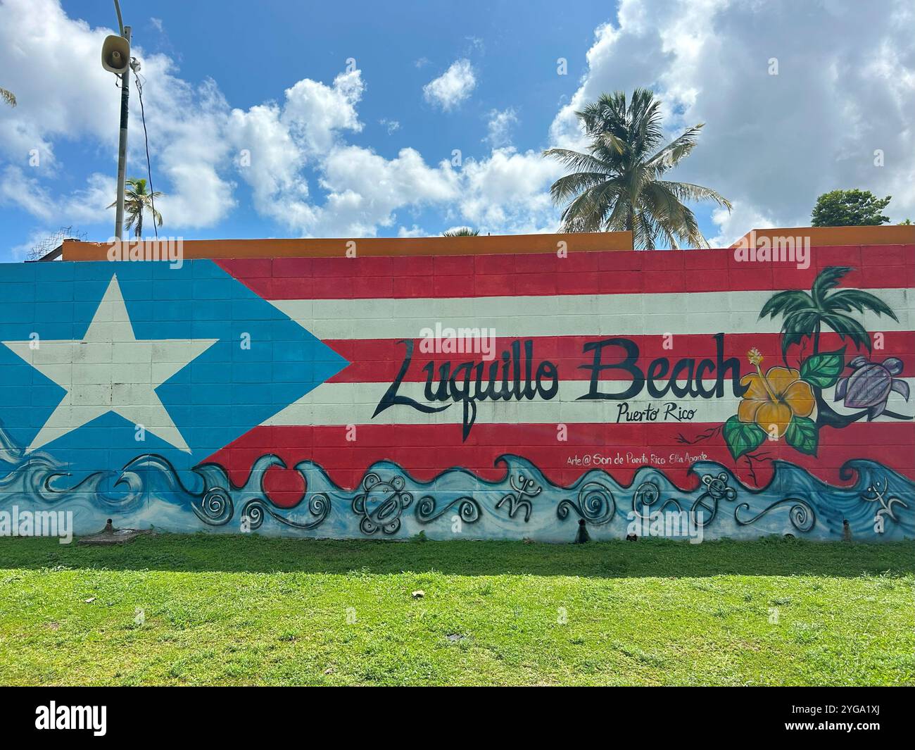 Das Bild zeigt ein farbenfrohes Wandbild an einer Wand, das die Puerto-ricanische Flagge mit den Worten „Luquillo Beach Puerto Rico“ darstellt - Smartphone-aufgenommenes Stockfoto