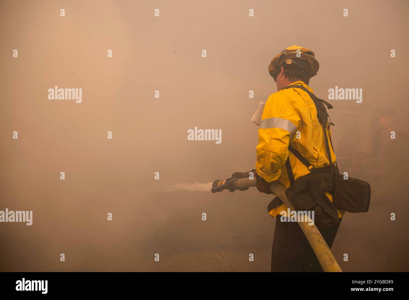 Camarillo, Usa. November 2024. Ein LAFD-Feuerwehrmann wird vom Rauch überholt, während er ein Feuer löscht. Das Bergfeuer brennt durch Camarillo mit Hilfe der Santa Ana Winde. Das Feuer hat derzeit mehr als 10.500 Hektar mit einer Rückhaltekapazität von 0 % verbrannt. (Foto: Jon Putman/SOPA Images/SIPA USA) Credit: SIPA USA/Alamy Live News Stockfoto