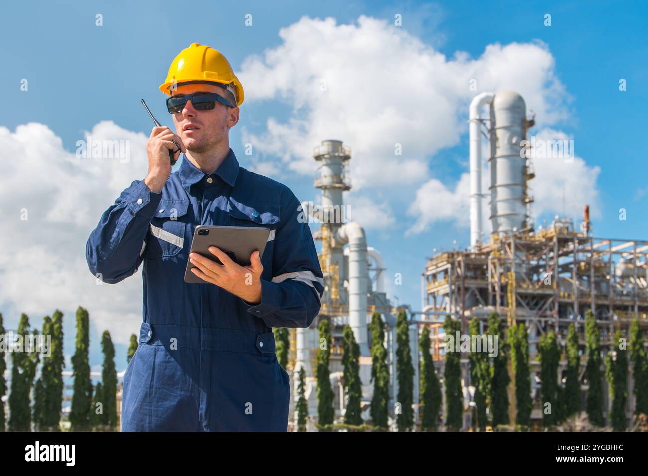 Arbeiter in der Erdölindustrie, der im Freien arbeitet. Der Leiter der Raffinerieöl- und Gasdienstleister führt die Instandhaltung komplexer Gasrohrgebäude mit Tablett durch Stockfoto