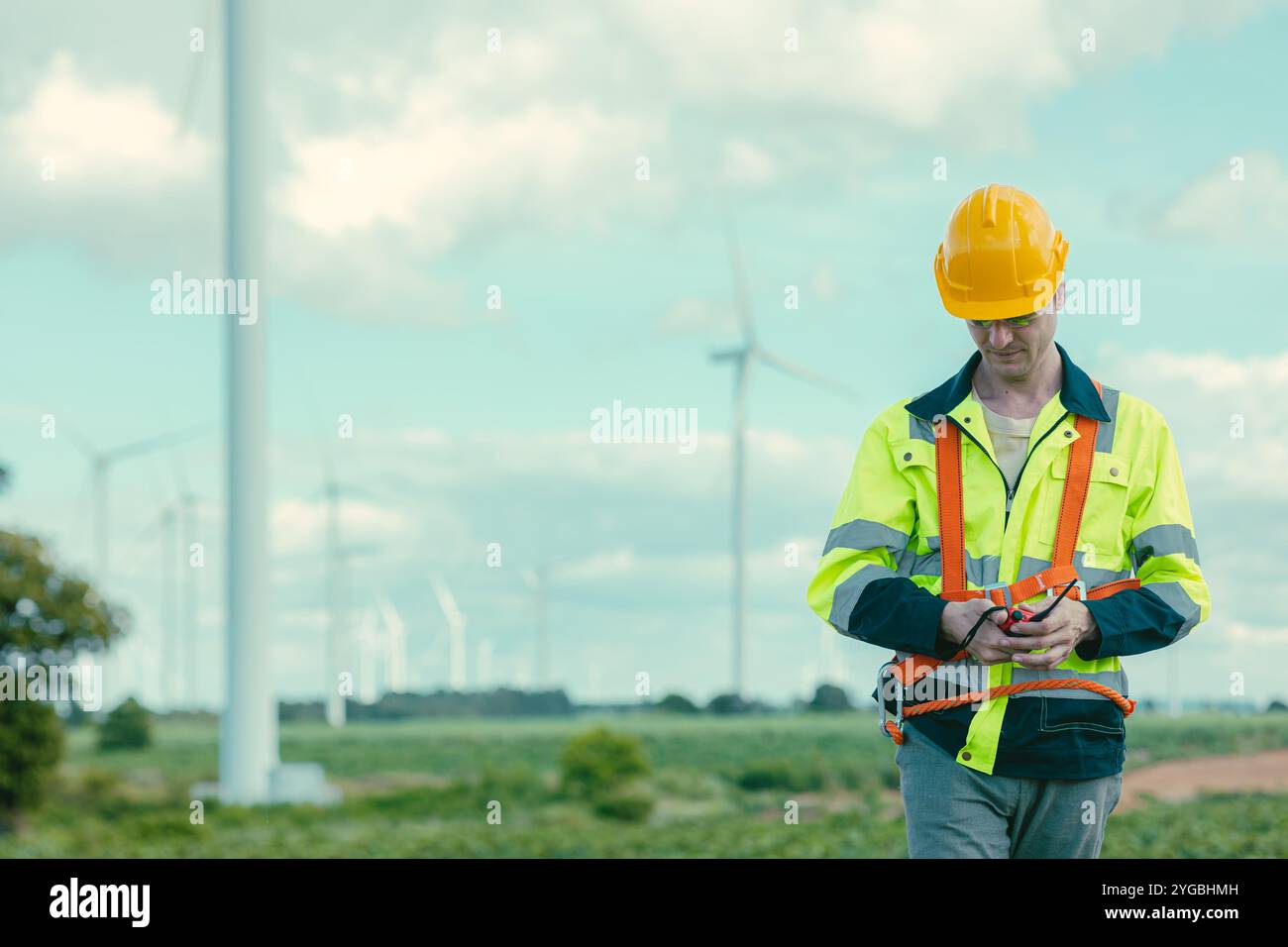 Kaukasischer Ingenieur Techniker männlicher Arbeiter Arbeitsdienst Wartung Windkraftanlage bei Wind Turbines Stromerzeuger Farm Feld im Freien. Stockfoto