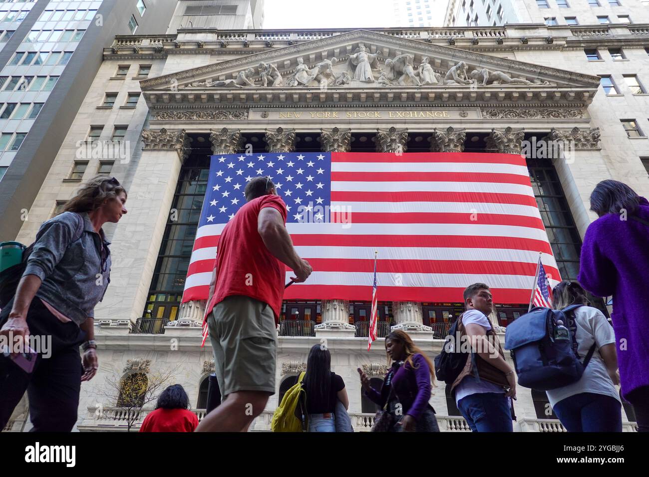 New York, USA, 6. November 2024. Fußgänger passieren die New Yorker Börse am 6. November 2024 Ortszeit. Die drei großen US-Aktienindizes stiegen von den US-Präsidentschaftswahlen 2024 stark an und erreichten Rekordhoch. Unter ihnen stieg der Dow Jones Industrial Average um 1.508,05 Punkte und erreichte 3,57 %, den größten Anstieg pro Tag seit zwei Jahren. Quelle: Wang Fan/China News Service/Alamy Live News Stockfoto