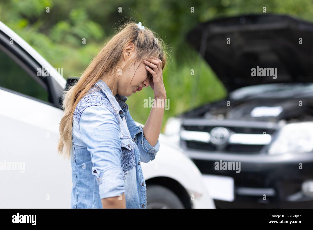 Frauen legen Wert auf langweilige Gefühle aufgrund von Autoproblemen, Fahrten, Fahrten, kaputten Autos oder einem Fahrzeugunfall am Straßenrand. Stockfoto