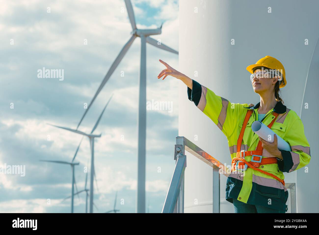 Weibliche Ingenieurin arbeitet im Freien mit Sicherheit an Windturbinen sauberen Energie Kraftwerk Hintergrund, Arbeiter Menschen mit erneuerbarer Energie Technologie für Stockfoto