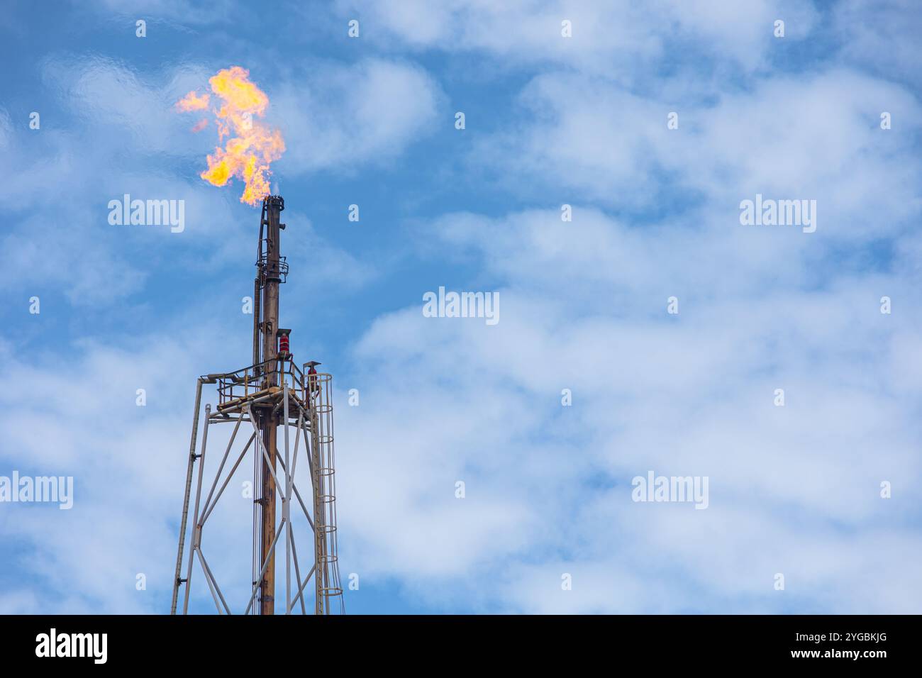 Methangas-Feuer-Plattform mit hohem Flare-Stack-Fackelturm in Raffinerien-Erdölanlagen oder Flammenbrand bei Offshore-Ölgewinnung. Stockfoto