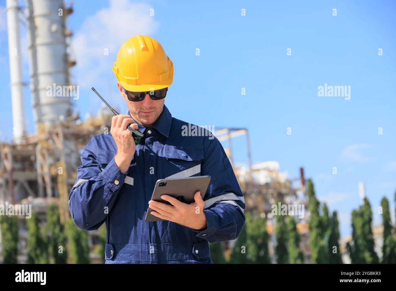 Industrielle Arbeiter Inspektion Verarbeitungsanlage Walkie Talkie Looking Tablet, Maschinenbau Industrie Sicherheit Im Freien Arbeiten Professionelle Kommunikation Ha Stockfoto