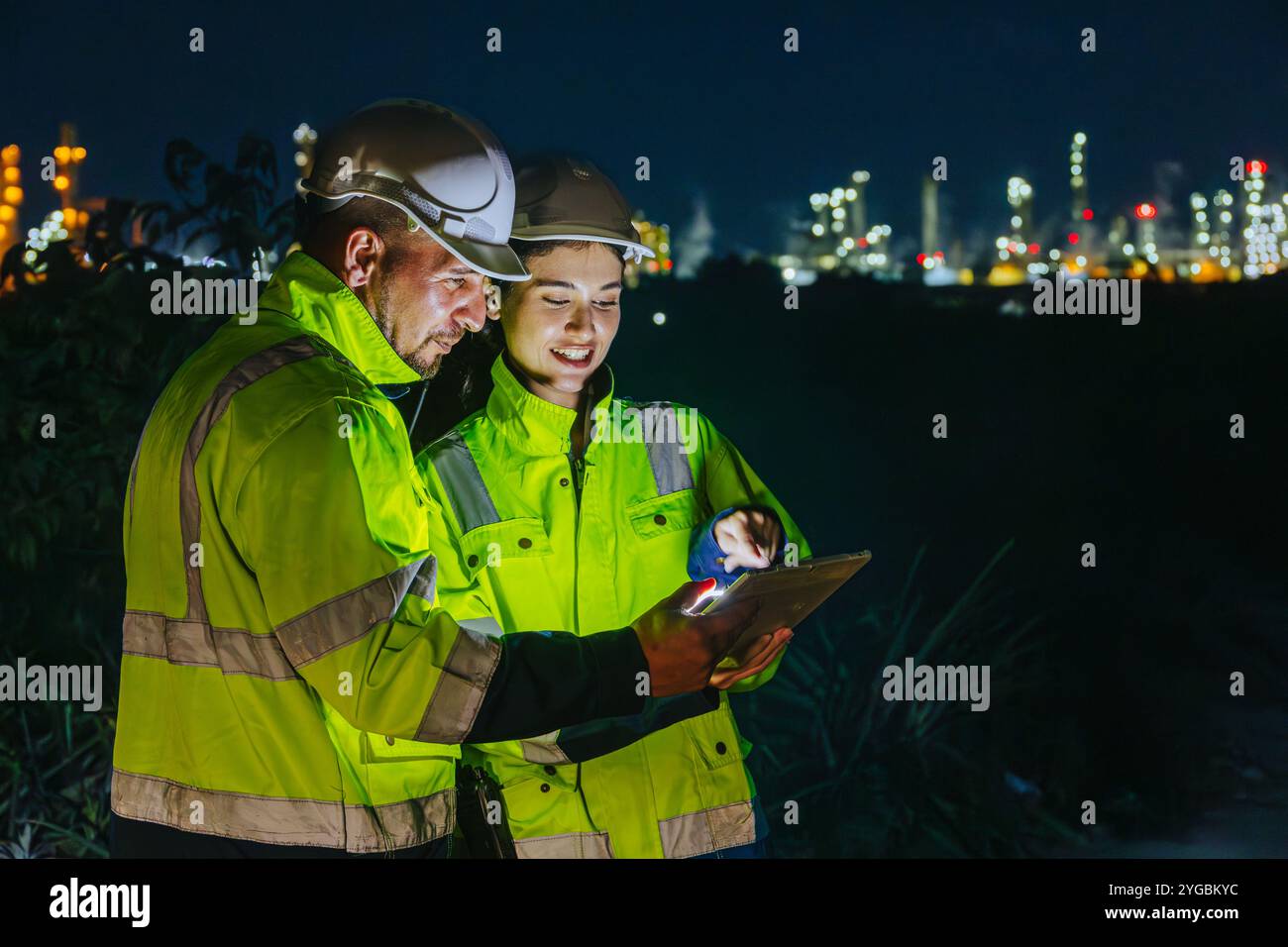 Nachtschicht Ingenieur Öl- und Gasraffinerie Service-Team Arbeiter harte Arbeit in der Erdölindustrie Werk Licht Unschärfe Hintergrund. Stockfoto