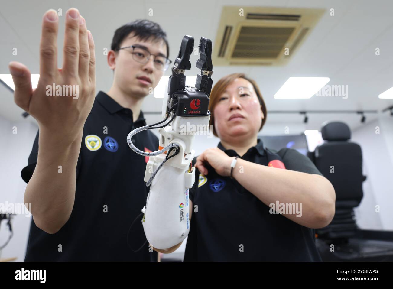 Mitglieder des wissenschaftlichen Forschungsteams der Southeast University und der behinderte Athlet Xu Min (rechts) demonstrieren die Funktion der „Mensch-Maschine-Fusion Bio-mechatronischen Prothetik Hand“. Nanjing, China, 5. November 2024. Vor Kurzem verwendete Xu Min beim Wettbewerb „Oberschenkelprothetik“ der dritten Olympischen Spiele in Zürich (Schweiz) die „Human-Machine Integrated Biomechatronics“, die vom Team von Professor Song Aiguo vom Institut für Robotersensorik und Steuerungstechnik der Southeast University entwickelt wurde. „Prothetische Hand“ gewann die Meisterschaft mit 10 Prothesen Stockfoto