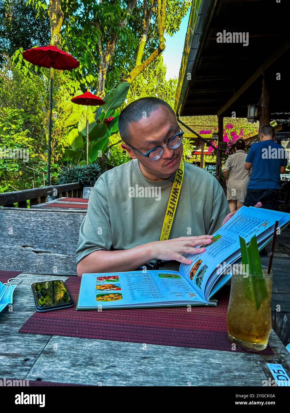 Chiang Mai, Thailand, traditionelles thailändisches Restaurant draußen, 'Baanrai Yarmyen', chinesischer Tourist, der alleine am Tisch auf der Terrasse isst Stockfoto