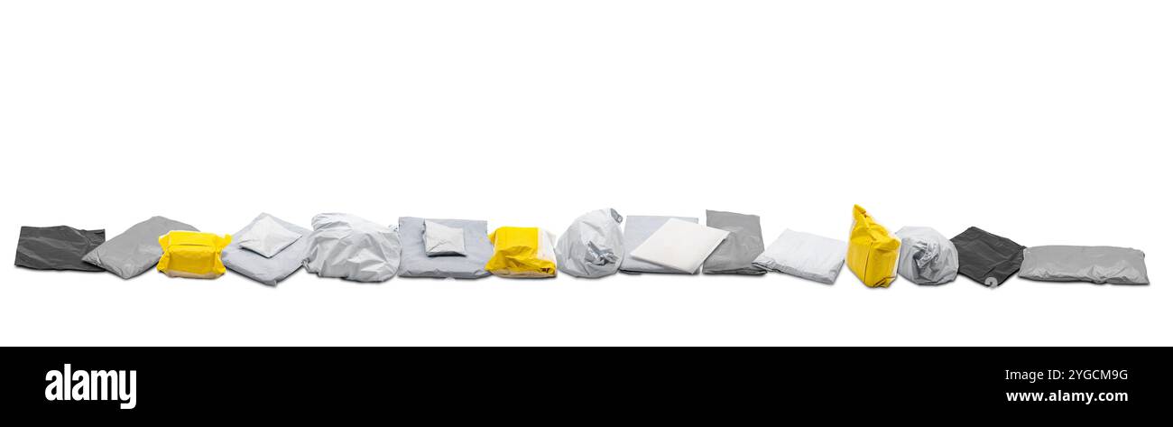 Die grauen und gelben Versandpaketsäcke wurden in einer Reihe auf weißem Hintergrund in einem Studio aufgenommen. Stockfoto