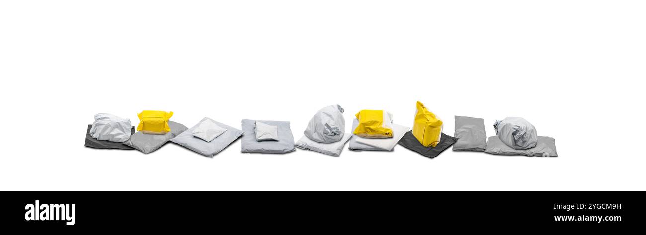 Die grauen und gelben Versandpaketsäcke wurden in einer Reihe auf weißem Hintergrund in einem Studio aufgenommen. Stockfoto