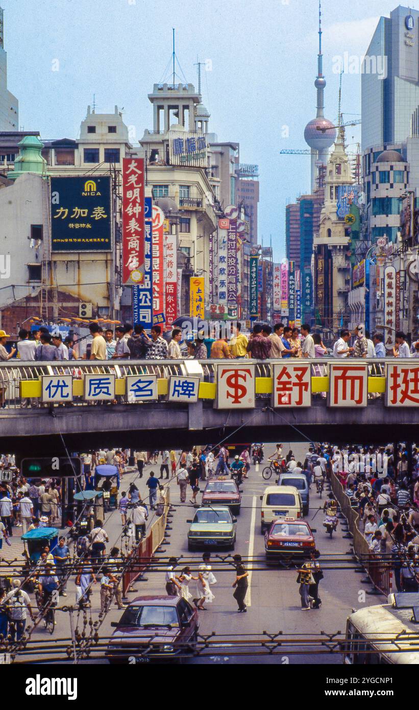China, Shanghai, geschäftige Einkaufsstraße mit Fußgängerüberflug in der Innenstadt. Stockfoto
