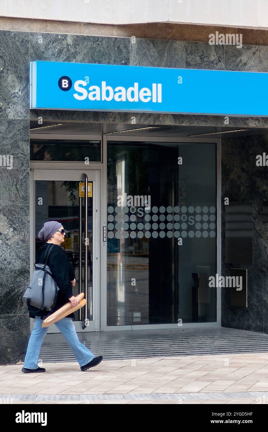 Viladecans. Spanien - 7. November 2024: Eingang Sabadell Bank mit Fußgänger Stockfoto