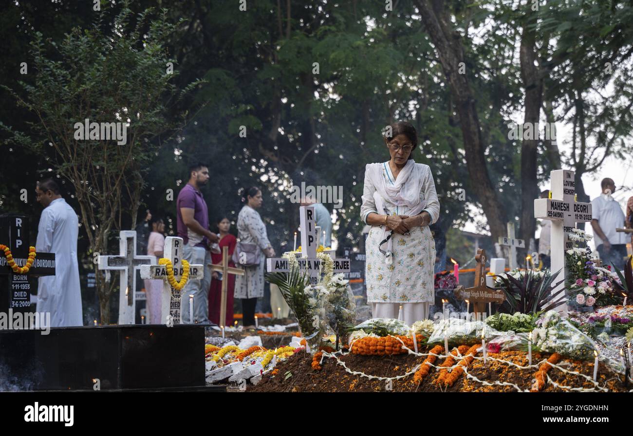 Menschen aus der christlichen Gemeinde zünden Kerzen an und beten auf dem Grab ihres Verwandten während der All Sels Day Observation in Guwahati, Indi Stockfoto