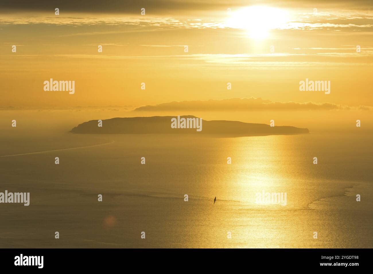 Kleine Insel und einsames Segelboot auf dem Meer während des dramatischen goldenen Sonnenuntergangs in der Nähe der Küste von Trapani, auf Sizilien, Italien, Europa Stockfoto