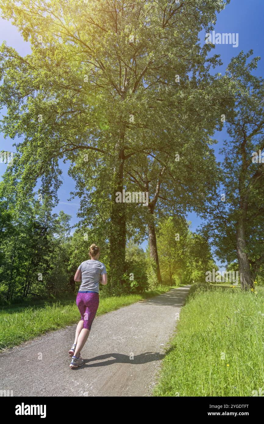 Junge Frau geht in einem schönen Park in der Nachmittagssonne laufen Stockfoto