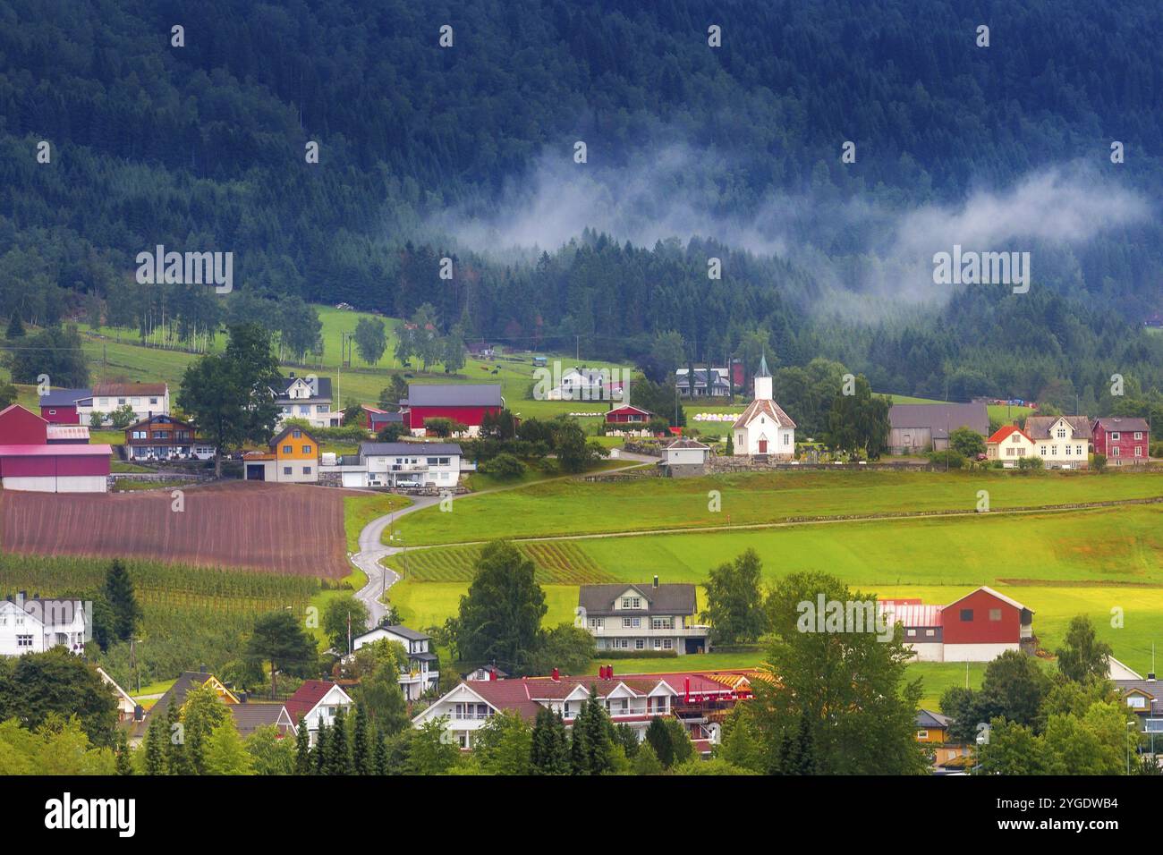 Norwegische Landschaft mit Bergen und Häusern im norwegischen Dorf Olden in der Nähe von Fjorden im Sommer Stockfoto