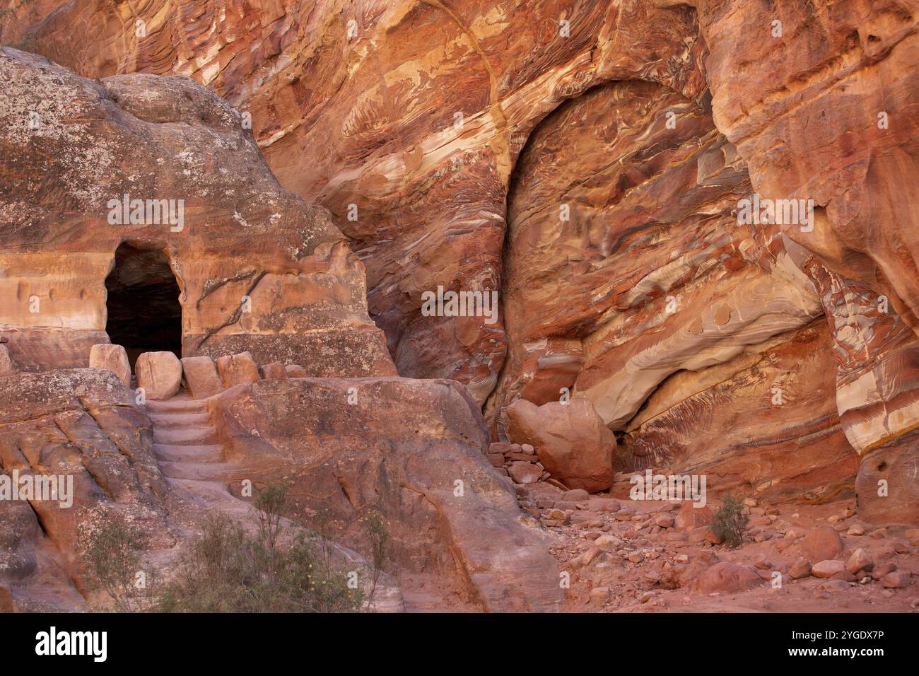 Petra, Jordanien, mehrfarbige Sandsteinfelsen und Mineralschichten und Höhle in alten Gräbern auf dem Wadi Farasah Trail Stockfoto