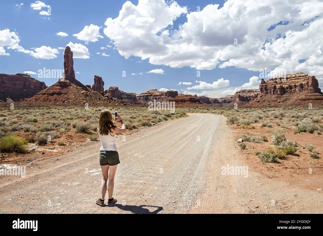 Junge Frau, die ein Foto in einer Wüstenlandschaft Stockfoto