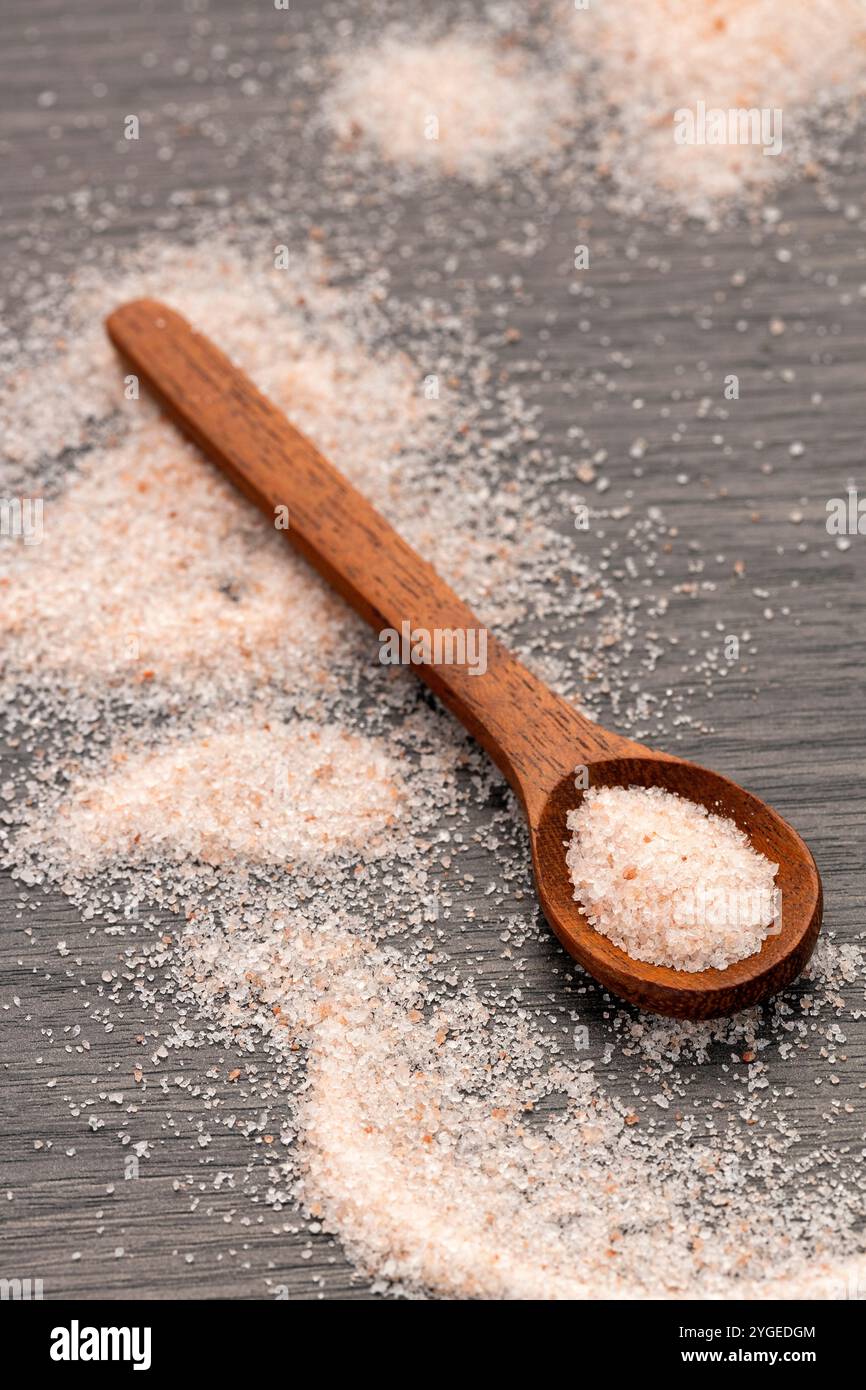 Feines Salz und rosafarbene Himalaya-Kristalle auf dem Löffel. Stockfoto