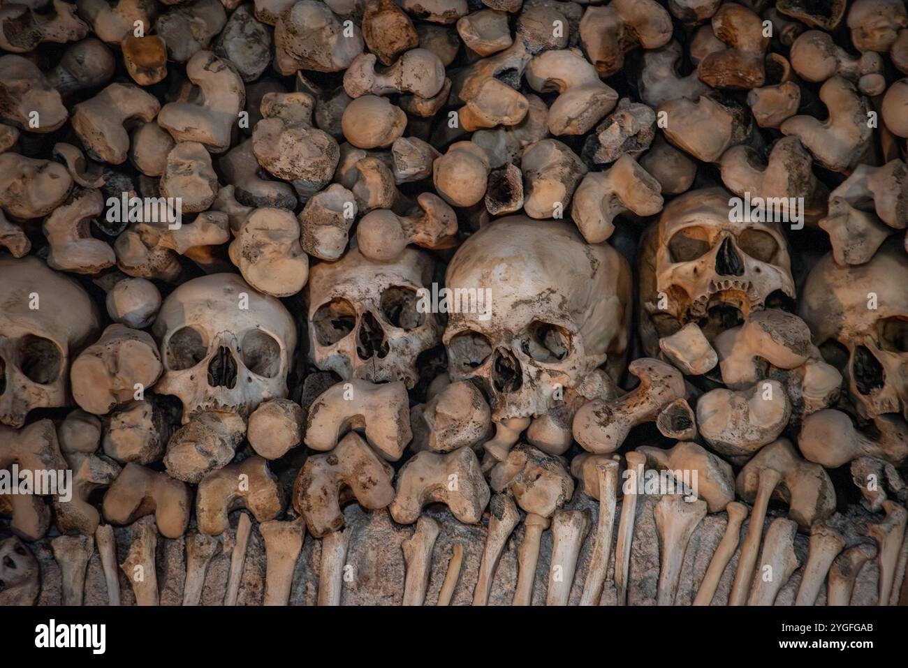 Gestapelte menschliche Knochen und Schädel, die in einem alten Kloster im Süden Europas zu einer Mauer gebaut wurden Stockfoto